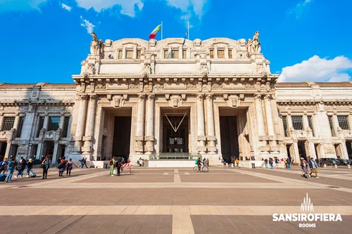 Facciata monumentale della Stazione Centrale di Milano al mattino con indicazione del percorso metro verso sansirofiera rooms B&B vicino a Fiera Milano Rho e San Siro